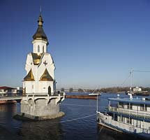 Kiew Flusshafen Retschnoj Woksal mit der Kirche Nikolaus des Wundertäters vom Architekten J. Losyz'kyj die gerade über dem Wasserspiegel des Fluss Dnepr steht und am 7. Juli 2003 geweiht wurde und einem Ausflugsschiff . Saint Nicholas church stands in the water of the river dnepr.