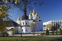 Kiew im Klostergarten des Michaelskloster Mychajlivs'kyj Zolotoverchyj monasty mit dem Kloster mit den goldenen Kuppeln, der Kirche mit Refektorium vorne links und dem Gebauede des Auswaertigen Amtes auswärtiges Amt, Ministerium fur auswaertige Angelegenheiten der Ukraine hinten rechts. Ukrainischer Barock. The St. Michael monastery, also spelled St. Michail's, mainly painted azure with a few golden domes on top of it