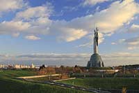 Kiew Statue der Mutter Heimat Rodina mat' mit Schwert und Schild im Park des Ruhmes aus Metall 108 m hoch einschliesslich Sockel aufgenommen an einem klaren Herbsttag bei tiefstehendem Sonnenlicht stimmungsvoll blauer Himmel mit Wolken . National Museum about the History of the Great Patriotic War against Nazi-Germany with the large monument "Rodina Mat'", lit. 'Mother Home country'. The monument itself is more than 100 m high and reminds the visitor of the devastating but glorious fight against Hitler.