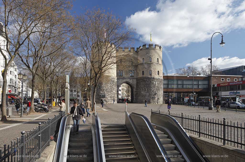 Koeln Altstadt Rudolfplatz mit Hahnentorburg Feldseite im Vorfruehling mit kahlen Baeumen, Kumuluswoilken und blauem Himmel, Cologne historical city gate in the old towm early spring time bare-brandched trees