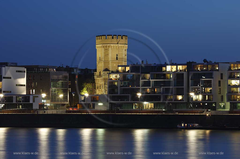 Koeln, der Bayenturm, mittelalterlicher Wehrturm, Sitz der Stiftung Frauenmediaturm in abendlicher Kunstlichtbeleuchtung, illuminiert, blaue Stunde, zwischen modernen Wohn- und Buerogebaeuden am Rheinauhafen, the Bayenturm, medieval defence tower in evening light, illlumination beween mordern buildings 