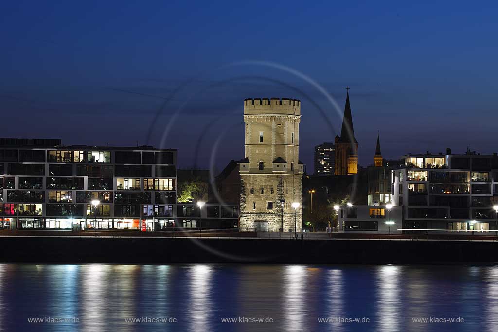 Koeln, der Bayenturm, mittelalterlicher Wehrturm, Sitz der Stiftung Frauenmediaturm in abendlicher Kunstlichtbeleuchtung, illuminiert, blaue Stunde, zwischen modernen Wohn- und Buerogebaeuden am Rheinauhafen, the Bayenturm, medieval defence tower in evening light, illlumination beween mordern buildings 