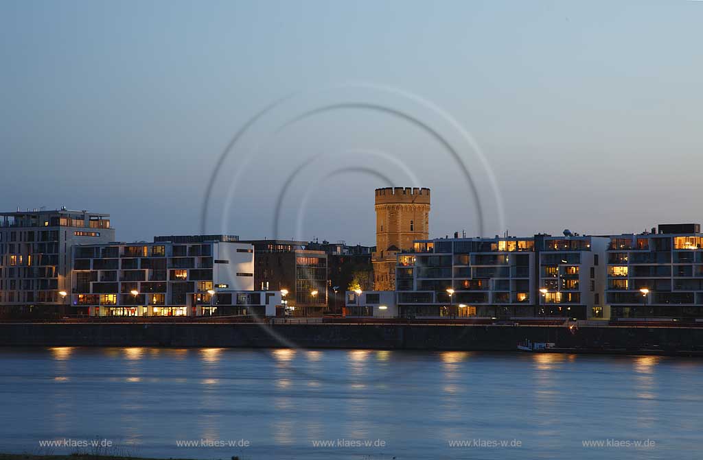 Koeln, der Bayenturm, mittelalterlicher Wehrturm, Sitz der Stiftung Frauenmediaturm in abendlicher Kunstlichtbeleuchtung, illuminiert, blaue Stunde, zwischen modernen Wohn- und Buerogebaeuden am Rheinauhafen, the Bayenturm, medieval defence tower in evening light, illlumination beween mordern buildings 