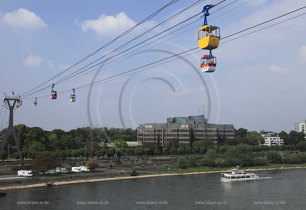 Koeln, Blick mit Rhein Seilbahn, der ersten Seilschwebebahn ueber einen Fluss, dem DEVK Versicherung Verwaltungsgebaeude mit der Koelner Kugel, ein Kunstwerk von H.A. Schult sowie einem Schiff der Weissen Flotte  Colonia 5 mit Passagieren, Anlagestelle Zoo / Flora Seilbahn; Cologne view with aereal passanger line, cableway, Rhine River, excursion boat, passangers, building with artwork of H.A. Schult: Cologne ball or Cologne globe