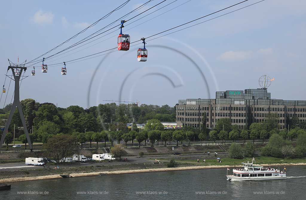 Koeln, Blick mit Rhein Seilbahn, der ersten Seilschwebebahn ueber einen Fluss, dem DEVK Versicherung Verwaltungsgebaeude mit der Koelner Kugel, ein Kunstwerk von H.A. Schult sowie einem Schiff der Weissen Flotte  Colonia 5 mit Passagieren, Anlagestelle Zoo / Flora Seilbahn; Cologne view with aereal passanger line, cableway, Rhine River, excursion boat, passangers, building with artwork of H.A. Schult: Cologne ball or Cologne globe