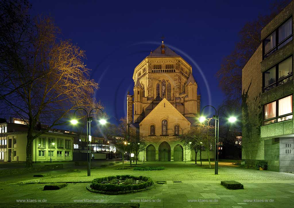 Koeln Altstadt, romanische Kirche St. Gereon im Fruehling mit kahlen Baeumen von West zur blauen Stunde illuminiert; Cologne old town romanesque church St. Gereon during blue hour