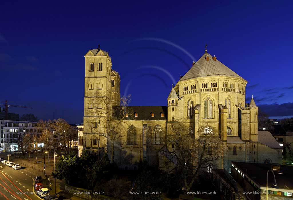 Koeln Altstadt, romanische Kirche St. Gereon im Fruehling mit kahlen Baeumen von Nord zur blauen Stunde illuminiert; Cologne old town romanesque church St. Gereon during blue hour