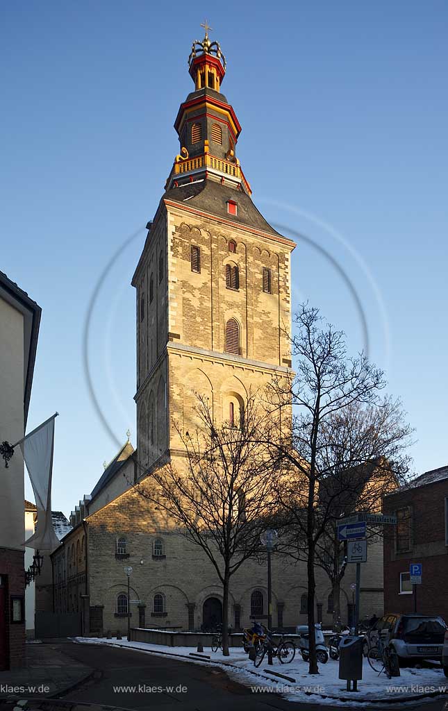 Koeln Altstadt, St. Ursula ist die aelteste niederrheinische dreischiffige Emporenbasilika. Blick zum massiven, romanisch gepraegten Westturm mit barocker Haubeim zur Winterzeit mit Schnee im Abendlich der untergehenden Sonne; Cologne steeple of romanesque church St. Ursula in evening sunset light in winter