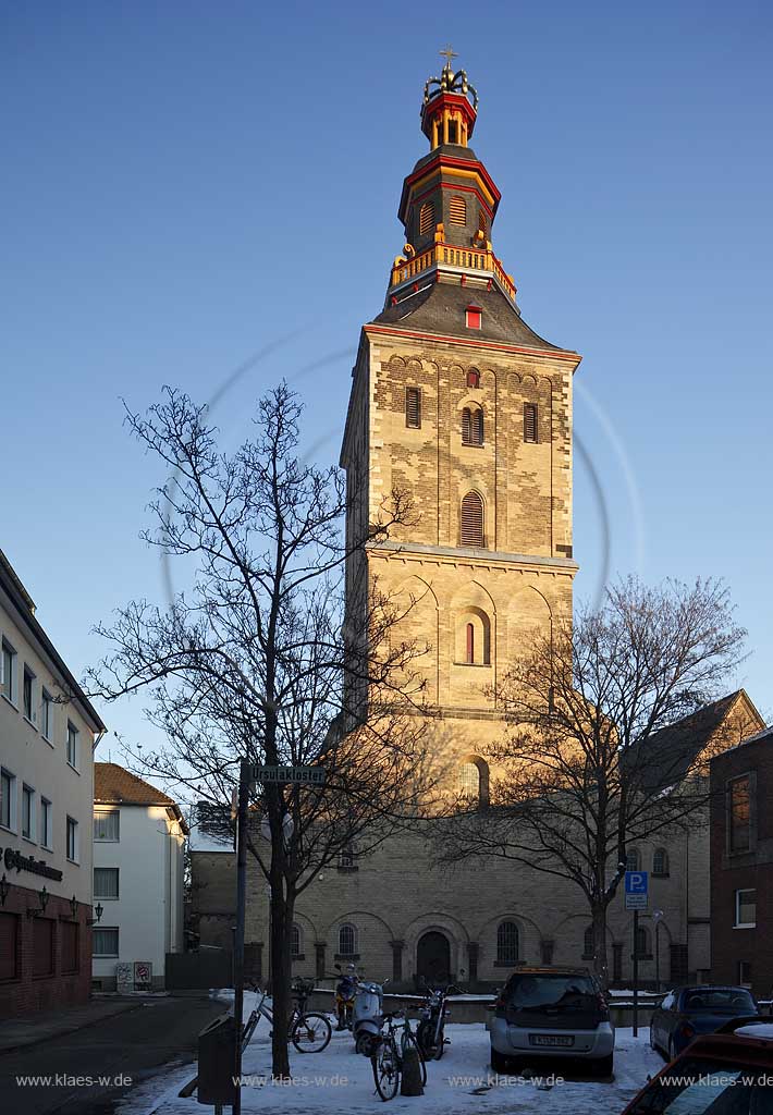 Koeln Altstadt, St. Ursula ist die aelteste niederrheinische dreischiffige Emporenbasilika. Blick zum massiven, romanisch gepraegten Westturm mit barocker Haubeim zur Winterzeit mit Schnee im Abendlich der untergehenden Sonne; Cologne steeple of romanesque church St. Ursula in evening sunset light in winter