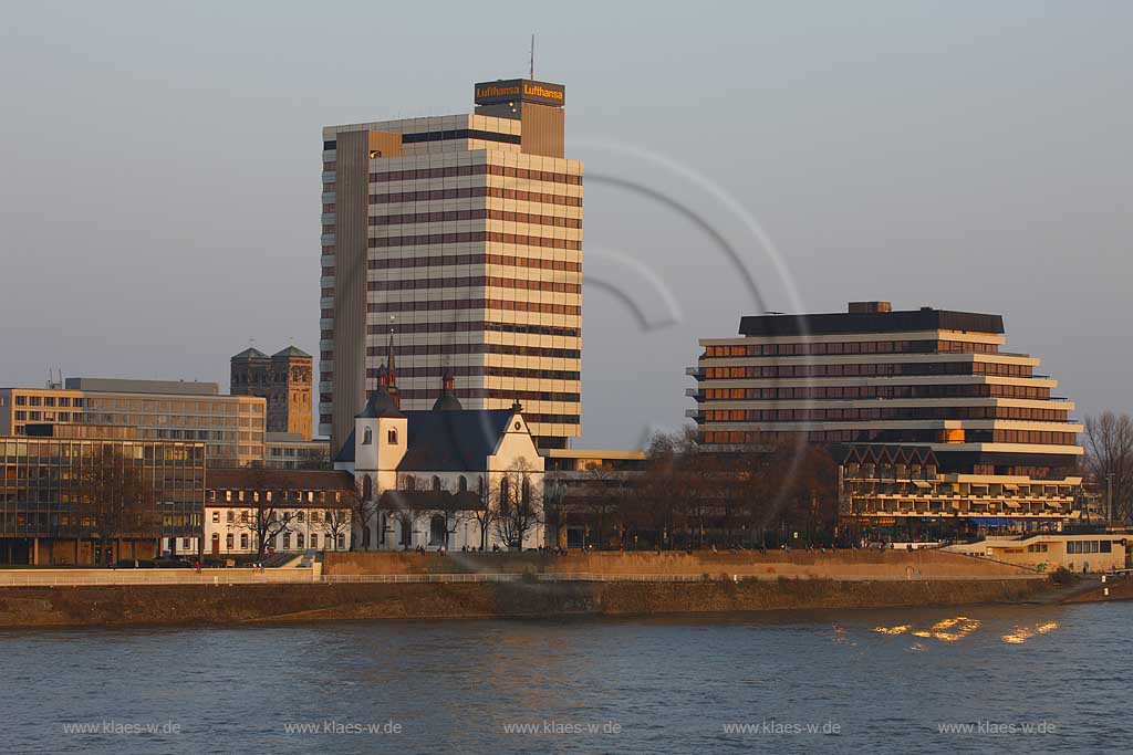 Koeln, Blick ber den Rhein nach Deutz mit der Kirche Alt Sankt Heribert, Abei Deutz, kleine romanische Kirche, vor dem ehemaligen Lufthansa Hochhaus im warmen roetlichen Licht der untegehenden Abendsonne;