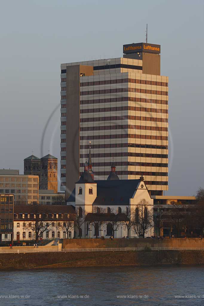 Koeln, Blick ber den Rhein nach Deutz mit der Kirche Alt Sankt Heribert, Abei Deutz, kleine romanische Kirche, vor dem ehemaligen Lufthansa Hochhaus im warmen roetlichen Licht der untegehenden Abendsonne;