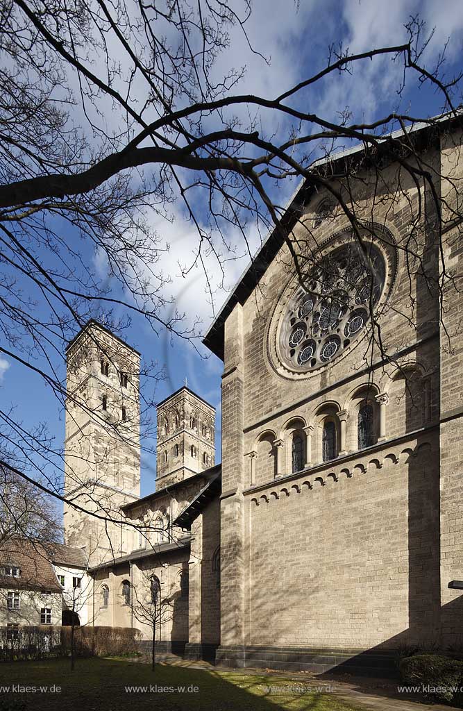 Koeln Deutz, Aussenansicht Hofseite von Suedwesten zu den beiden Kirchtuermen der Pfeilerbasilika St. Heribert im Fruehling mit kahlen Baeumen; Cologne Deutz southwest side with steeples of basilica St. Heribert