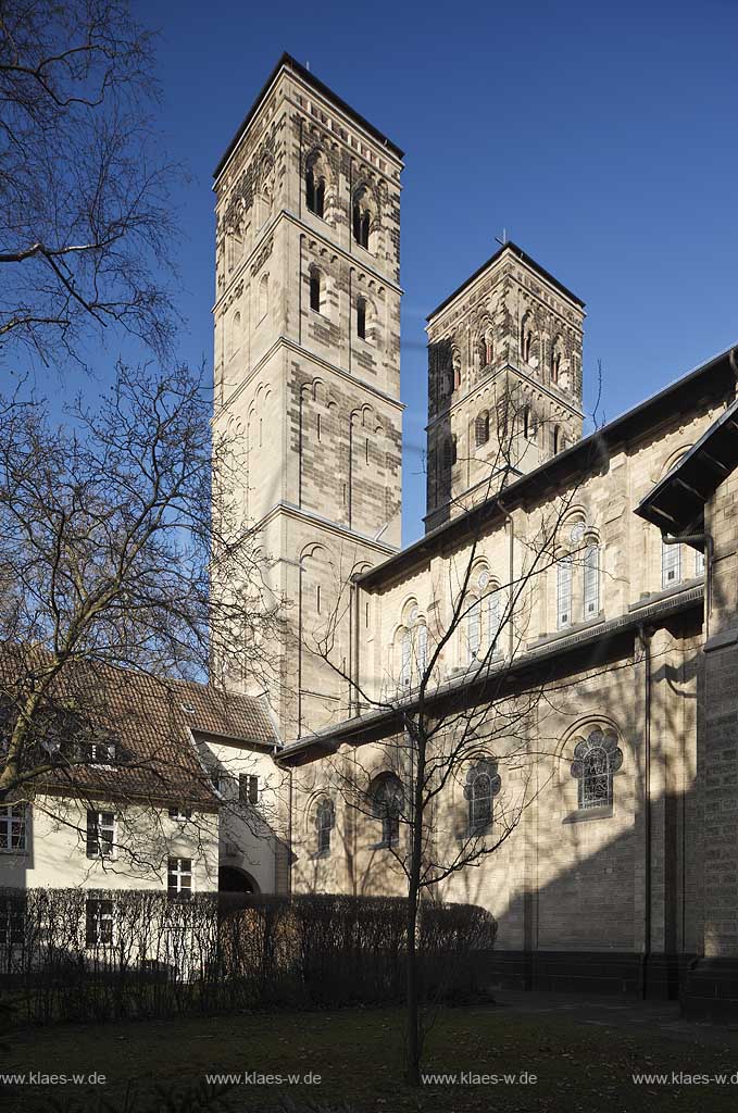 Koeln Deutz, Aussenansicht Hofseite von Suedwesten zu den beiden Kirchtuermen der Pfeilerbasilika St. Heribert im Fruehling mit kahlen Baeumen; Cologne Deutz southwest side with steeples of basilica St. Heribert