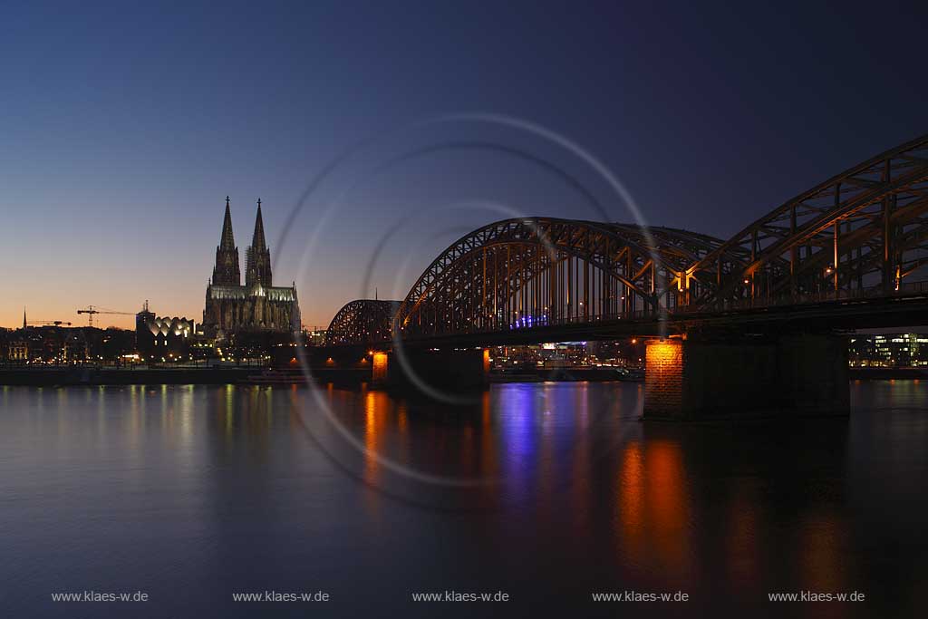 Koeln Blick ueber den Rhein auf den illuminierten Klner Dom und Hohenzollern Bruecke rechts zur blauen Stunde bzw. abendlicher Beleuchtung; Cologne view over rhine to the cathedral and Hohenzollern bridge right side with illumination light