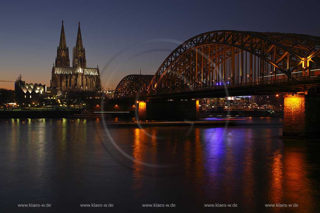 Koeln Blick ueber den Rhein auf den illuminierten Klner Dom und Hohenzollern Bruecke rechts zur blauen Stunde bzw. abendlicher Beleuchtung; Cologne view over rhine to the cathedral and Hohenzollern bridge right side with illumination light