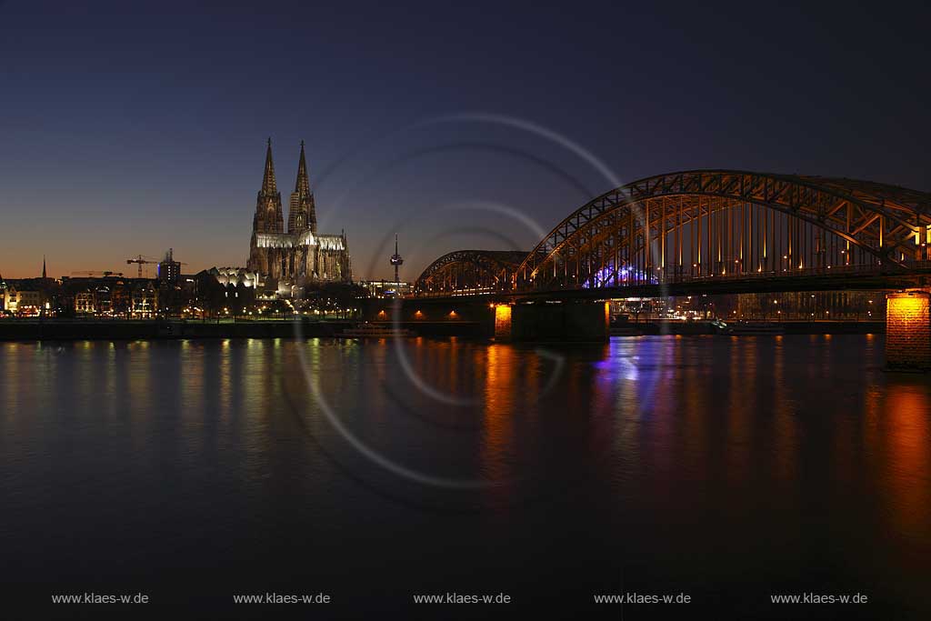 Koeln Blick ueber den Rhein auf den illuminierten Klner Dom und Hohenzollern Bruecke rechts zur blauen Stunde bzw. abendlicher Beleuchtung; Cologne view over rhine to the cathedral and Hohenzollern bridge right side with illumination light