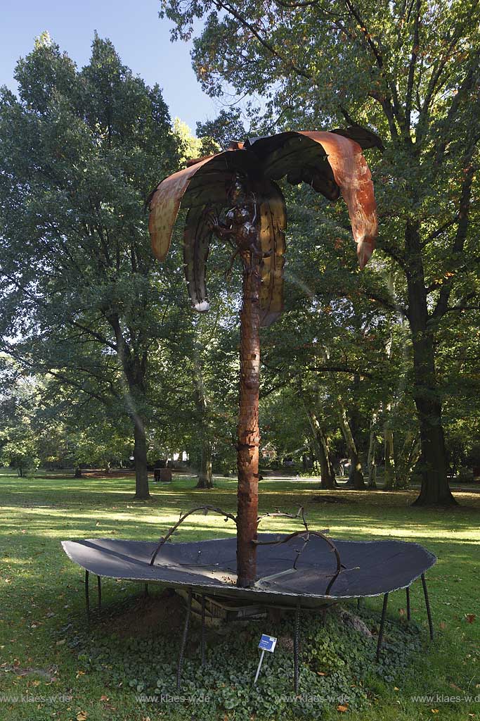 Koeln-Stammheim Schlosspark Skulpturenpark, Tobi Moehring zeigt in seiner Arbeit, der Metallskulptur Affenklima, 2007 wie nah die Phantasie hier schon an der Wirklichkeit ist. Im 2006/2007 so extrem warmen Winter stellte sich der aus Stammheim stammende Kuenstler eine naheliegende Frage: Wie lange dauert es noch, bis in Deutschland die Affen unter den Baeumen turnen ? Seine Antwort zeigt eine Palme deren Kokosnsse leuchten und unter der kleine Affen turnen; Cologne-Stammheim park of castle with sculpture from Tobi Moehring 