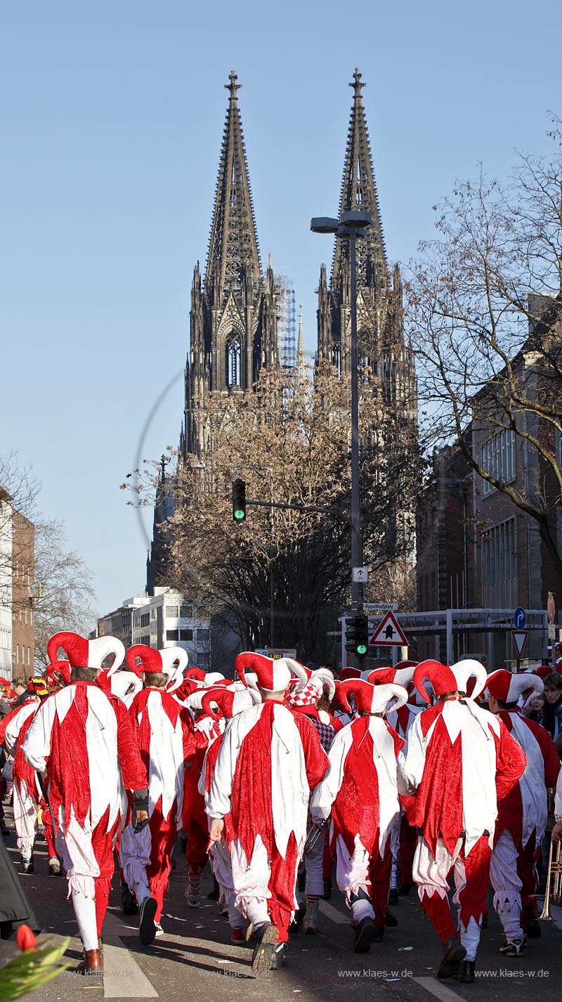 Koeln Altstadt,  Rosenmontag Rosenmontagszug, Fusstruppe in Narrenkostuemen rot weiss zieht auf den  Koelner Dom im Hintergrund zu; Cologne Carnival, in the background cathedrale of Cologne