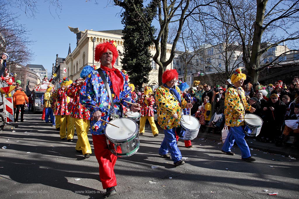 Koeln Altstadt,  Rosenmontag Rosenmontagszug, Spielmannszug zieht in bunten Clownkostuemen durch die Zeughausstrasse bei strahlend blauem Himmel; Cologne Carnival