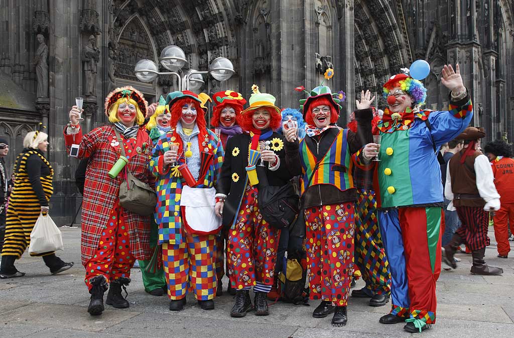 Koeln Domplatte waehrend Altweiberfasnacht, Altweiberfasching, Altweiber feiernde Moehnen hier verkleidet als Clown in bunten Kostuemen im Karneval vor dem Dom