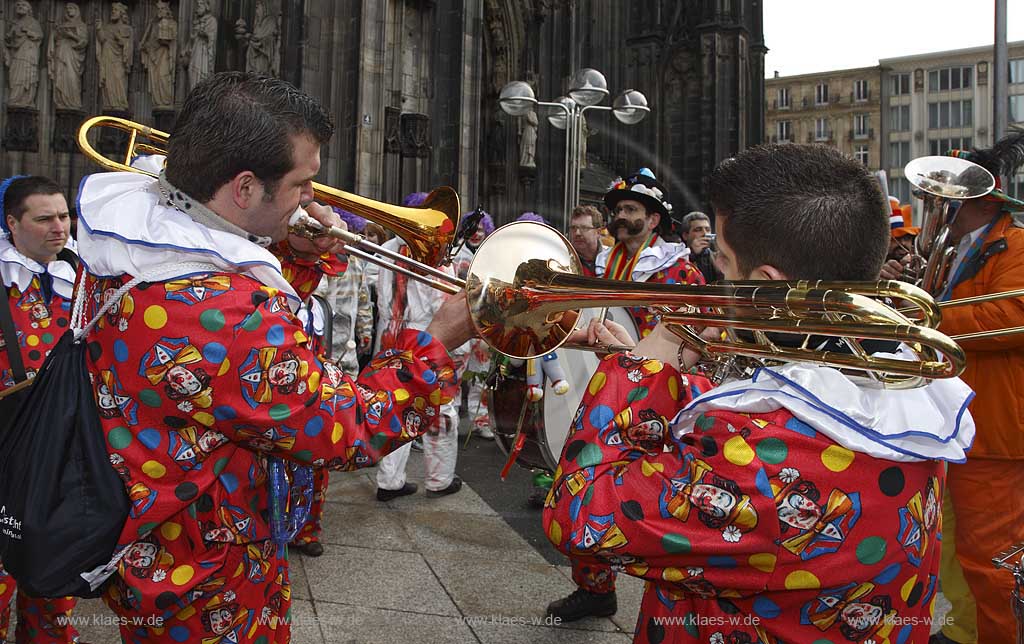 Koeln Domplatte waehrend Altweiberfasnacht, Altweiberfasching, Altweiber spielende Kapelle Musikgruppe in bunten Kostuemen vor dem Dom