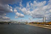 Koeln, Blick von der Deutzer Bruecke ueber den Rhein zur Hohenzollernbruecke mit Eisenbahn IC, dem Messeturm und Koelntriangel Hochhaus mit stimmungsvollem Wolkenhimmel; Cologne view from bridge Deutzer Bruecke to Hohenzollern bridge with IC rail, tower of fair and Colognetriangle with atmospheric clouds in the blue sky