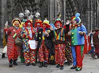 Koeln Domplatte waehrend Altweiberfasnacht, Altweiberfasching, Altweiber feiernde Moehnen hier verkleidet als Clown in bunten Kostuemen im Karneval vor dem Dom