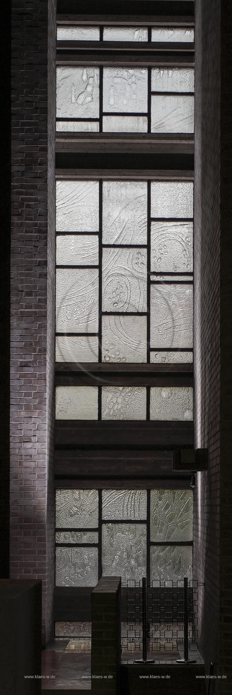 Bonn-Limperich, die katholische Pfarrkirche Heilig Kreuz, entstanden nach Plaenen von Architekt Professor "Alexander Freiherr von Branca". Blick auf die Verglasung der Fensterbahnen mit Schmelzglas, ein innovatives Glasprojekt nach "Florian Lechner", nach dessen Ideen und Entwuerfen sie in einer Amsterdamer Glasfirma "Tetterode" ueber Sand geschmolzen wurden. Keine Scheibe gleicht der anderen; Bonn-Beuel Limperich, catholic parish church Heilig Kreuz, view to the glazing of the windows with glass Schmelzglas.