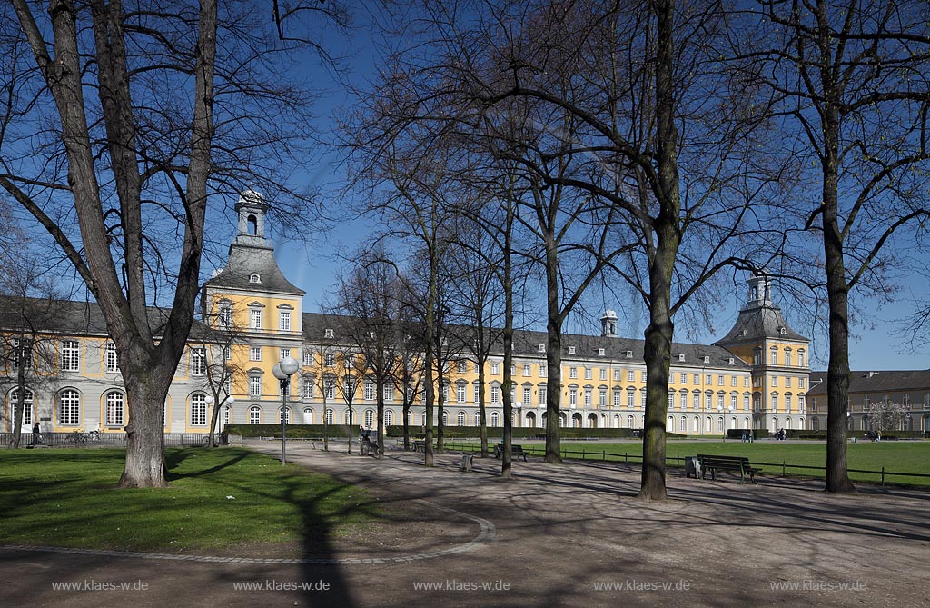 Bonn, kurfuerstliches Schloss im Fruehling mit kahlen Baeumen,Parkweg, Baenken und Menchen; Bonn elector castle in springtime