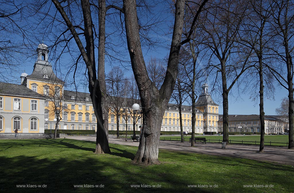 Bonn, kurfuerstliches Schloss im Fruehling mit kahlen Baeumen,Parkweg, Baenken und Menchen; Bonn elector castle in springtime