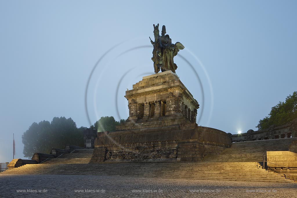 Koblenz, Deutsches Eck, Morgenstimmung blaue Stunde illuminiertes monumentales Reiterstanbild Kaiser Wilhelm I., Nebelstimmung; Koblenz Deutsches Eck equestrian statue of emperor Wilhem I. during blue hour, illuminated in fog.