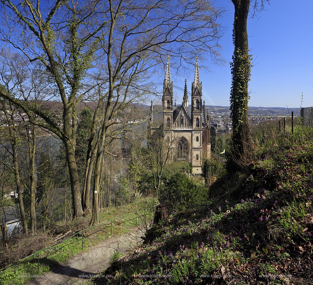 Remagen Blick vom Apollinarisberg auf die Apollianariskirche mit Weg und Pflanzen im Vordergrund im Fruehling mit kahlen Baeumen; Remagen view from hill Apollinarisberg to Apollianarischurrch in springtime