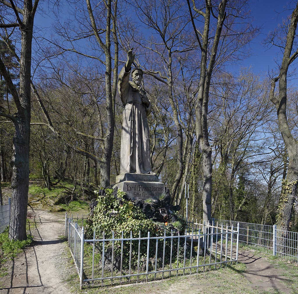 Remagen Apollinarisberg, die segnende Franziskustatue ist ein Symbol fr die Verbundenheit der Stadt Remagen mit dem Apollinarisberg und den Franziskanern, die rund 150 Jahre hier seelsorglich taetig waren. Im Jahr 1886 wurde die ueberlebensgross 3,8 meter hohe Statue auf den Anhoehe oberhalb der Apollinariskirche eingeweiht werden. Der Koelner Kuenstler Joseph Albermann hatte sie gestalte, Ansicht von vorne, Vorderansicht mit Gesicht, frontal im Fruehlingt Remagen sculture of Franziskus at the Apollinarisberg in springtime