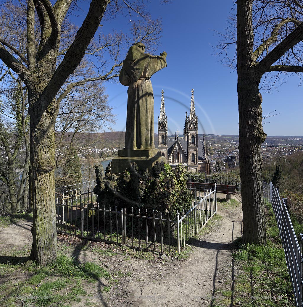 Remagen Apollinarisberg, die segnende Franziskustatue ist ein Symbol fr die Verbundenheit der Stadt Remagen mit dem Apollinarisberg und den Franziskanern, die rund 150 Jahre hier seelsorglich taetig waren. Im Jahr 1886 wurde die ueberlebensgross 3,8 meter hohe Statue auf den Anhoehe oberhalb der Apollinariskirche eingeweiht werden. Der Koelner Kuenstler Joseph Albermann hatte sie gestalte, Rueckseite, Rueckansicht von hinten mit Blick auf die Apollinariskirche im Fruehlungt Remagen sculture of Franziskus at the Apollinarisberg in springtime, rear side