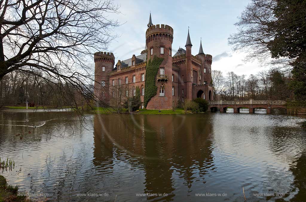 Bedburg-Hau, Schloss Moyland im Fruehling in stimmungsvollem Abendlcht, mit kahlen Aesten, aktuelle Aufnahme mit dem neuen Helm auf dem Nordturm, Nordturmhelm, in stimmungsvollem Abendlcht; Bedburg-Hau castle Moyland in springtime