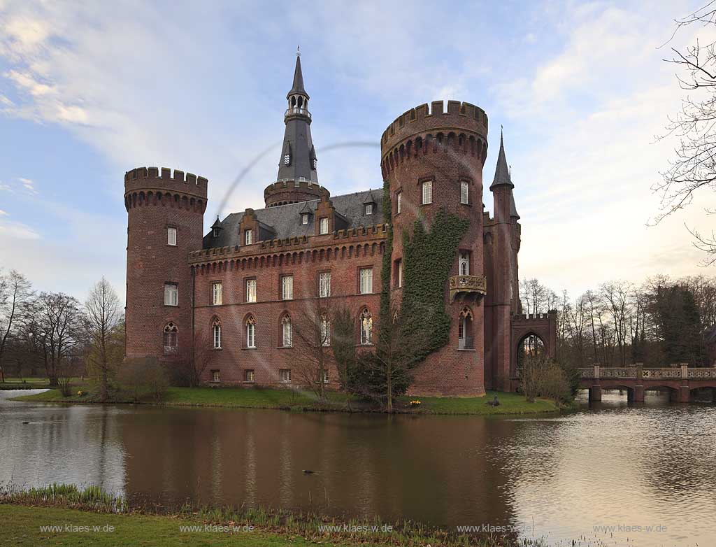 Bedburg-Hau, Schloss Moyland im Fruehling in stimmungsvollem Abendlcht, mit kahlen Aesten, aktuelle Aufnahme mit dem neuen Helm auf dem Nordturm, Nordturmhelm, in stimmungsvollem Abendlcht; Bedburg-Hau castle Moyland in springtime