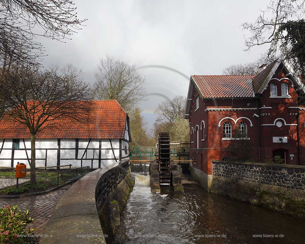 Dinslaken Hiesfeld Muehlenmuseum Wassermuehle im Fruehling mit Wasserad, im Hintergrund Regenbogen, kahle Baeume; Dinslaken-Hiesfeld museum water mill with mill wheel in springtimewith a rainbow in the background