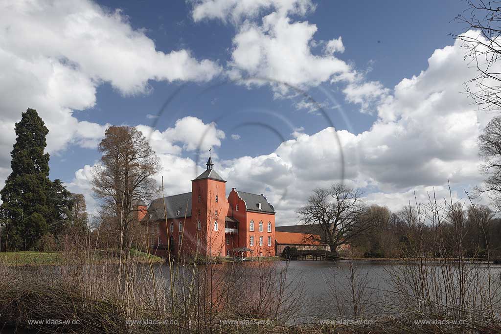 Neukirchen-Vlyn Schloss Bloemersheim, Wasserschloss aus dem Spaetmittelalter, Blick zur rueckwaertigen Seite ueber den Schlossweiher im Fruehling mit kahlen Bauemen,Wolkenstimmung windig bis stuermisch; Kamp-Lintfort water moated castle Bloemersheim in springtime  impression with clouds