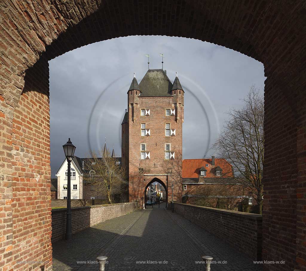 Xanten, Stimmung mit dunklen Wolken, sonnig, Klever Tor im Fruehling mit kahlen Baeumen; Kleve impression with towngate Klever Tor in springtime with dark clouds