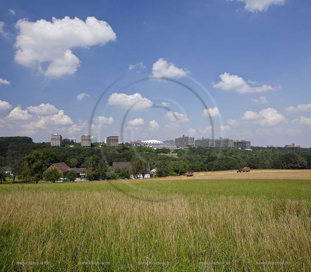 Bochum, Blick zur Ruhruniversitaet mit Wiese und Landwirtschaft, Fachwerkhof im Vordergrund, Erntemaschinen, Traktor und Bauer, Baeuerin mit Trecker rechts im Bild, Kumuluswolken an blauem Himmel in Sommerlandschaft; Bochum view to Ruhr univeritiy in contrast to agriculute in front with farm, framework house, reaper and  and tractor, summer landscape with Cumulus clouds and blue sky