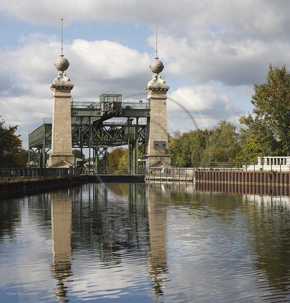 Castrop-Rauxel Henrichenburg Schiffshebewerk am Dortmund-Ems-Kanal in Ansicht von oben, also vom Oberwasser aus auf die Oberhaupttuerme mit Stahl Fachwerkkonstruktion mit dem Preussischen Adler an der Verbindungsbruecke an einem stimmungsvollen Herbsttag mit Wolken und Spiegelbild im Oberwasser, Route Industriekultur; Historical shiop hoist or ship lift Henrichenburg