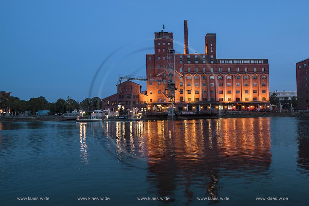 Duisburg, Innenhafen, Blick zur "Wehrhahnmuehle" mit Wasserspiegelung zur Blauen Stunde, die ehemalge "Cohen Muehle" wird heutzutage als Buero-, Museums- und Gastronomiekomplex genutzt; Duisburg, inner harbour, view to the "Wehrhanmuehle" former "Cohen Muehle", a former mill which is used as office block, museum and restaurants today.