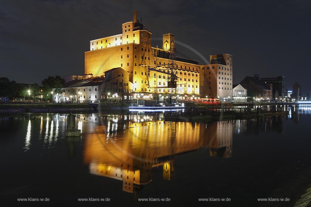 Duisburg, Innenhafen, Blick zur "Wehrhahnmuehle" mit Wasserspiegelung Nachtaufnahme bei Mondschein, die ehemalge "Cohen Muehle" wird heutzutage als Buero-, Museums- und Gastronomiekomplex genutzt; Duisburg, inner harbour, view to the "Wehrhanmuehle" former "Cohen Muehle", a former mill which is used as office block, museum and restaurants today, night shot while moonlight with mirroring in the water.