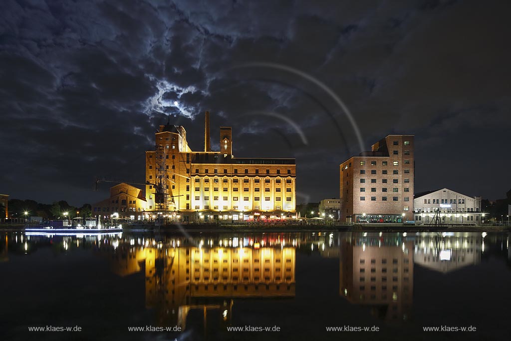  Duisburg, Innenhafen, Blick zur "Wehrhahnmuehle" mit Wasserspiegelung Nachtaufnahme bei Mondschein mit stimmungsvollem Wolkenhimmel, die ehemalge "Cohen Muehle" wird heutzutage als Buero-, Museums- und Gastronomiekomplex genutzt; Duisburg, inner harbour, view to the "Wehrhanmuehle" former "Cohen Muehle", a former mill which is used as office block, museum and restaurants today, night shot while moonlight with mirroring in the water and impressive clouded sky.