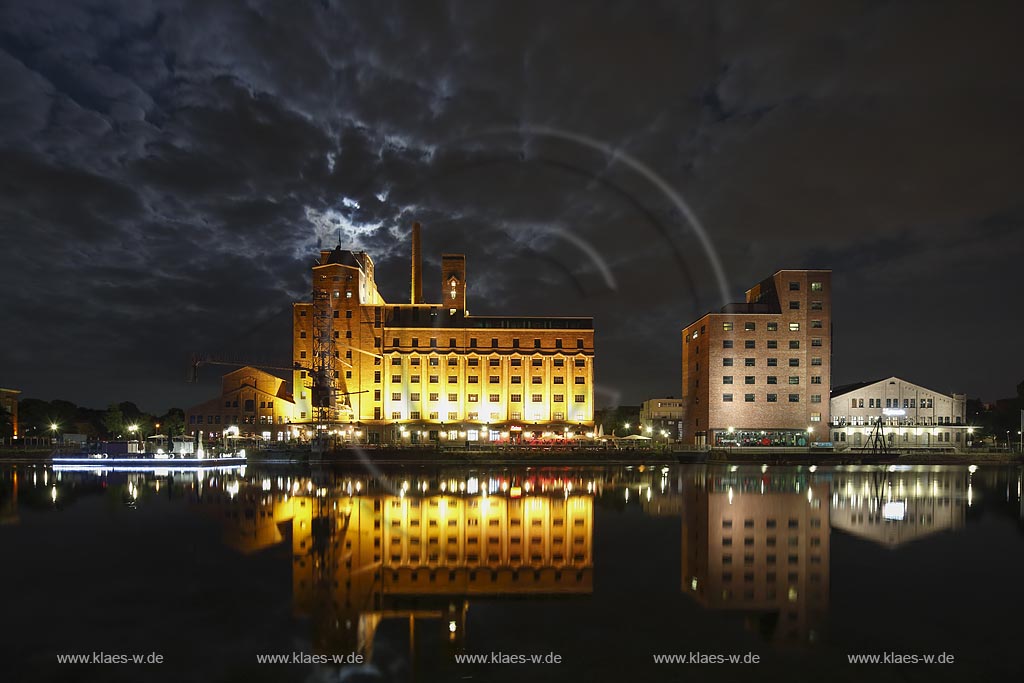  Duisburg, Innenhafen, Blick zur "Wehrhahnmuehle" mit Wasserspiegelung Nachtaufnahme bei Mondschein mit stimmungsvollem Wolkenhimmel, die ehemalge "Cohen Muehle" wird heutzutage als Buero-, Museums- und Gastronomiekomplex genutzt; Duisburg, inner harbour, view to the "Wehrhanmuehle" former "Cohen Muehle", a former mill which is used as office block, museum and restaurants today, night shot while moonlight with mirroring in the water and impressive clouded sky.