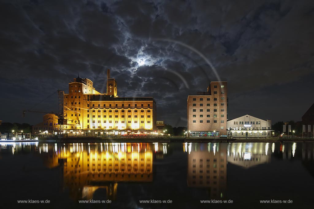  Duisburg, Innenhafen, Blick zur "Wehrhahnmuehle" mit Wasserspiegelung Nachtaufnahme bei Mondschein mit stimmungsvollem Wolkenhimmel, die ehemalge "Cohen Muehle" wird heutzutage als Buero-, Museums- und Gastronomiekomplex genutzt; Duisburg, inner harbour, view to the "Wehrhanmuehle" former "Cohen Muehle", a former mill which is used as office block, museum and restaurants today, night shot while moonlight with mirroring in the water and impressive clouded sky.