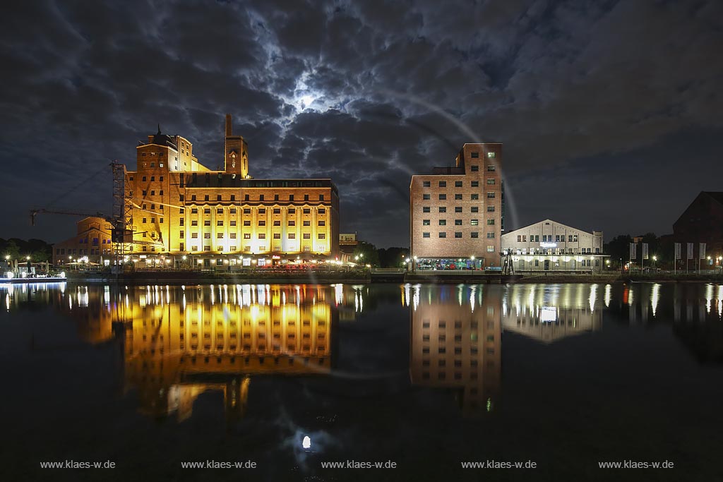  Duisburg, Innenhafen, Blick zur "Wehrhahnmuehle" mit Wasserspiegelung Nachtaufnahme bei Mondschein mit stimmungsvollem Wolkenhimmel, die ehemalge "Cohen Muehle" wird heutzutage als Buero-, Museums- und Gastronomiekomplex genutzt; Duisburg, inner harbour, view to the "Wehrhanmuehle" former "Cohen Muehle", a former mill which is used as office block, museum and restaurants today, night shot while moonlight with mirroring in the water and impressive clouded sky.