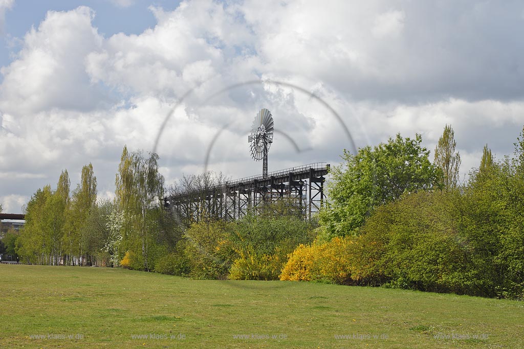 Duisburg Meiderich. Parklandschaft mit Windenergieturm, Wolkenstimmung. Der Landschaftspark Duisburg-Nord, auch kurz LaPaDu ist ein etwa 200 Hektar groer Landschaftspark rund um ein stillgelegtes Huettenwerk in Duisburg-Meiderich, das im Rahmen der IBA (Internationale Bauausstellung Emscher Park) entstand. Der Landschaftspark ist einer der Ankerpunkte der Europaeischen Route der Industriekultur sowie der Route der Industriekultur im Ruhrgebiet;  Duisburg-Meiderich, the Meiderich ironworks are the main feature in the North Duisburg Landscape Park, park landscape with wind turbine tower