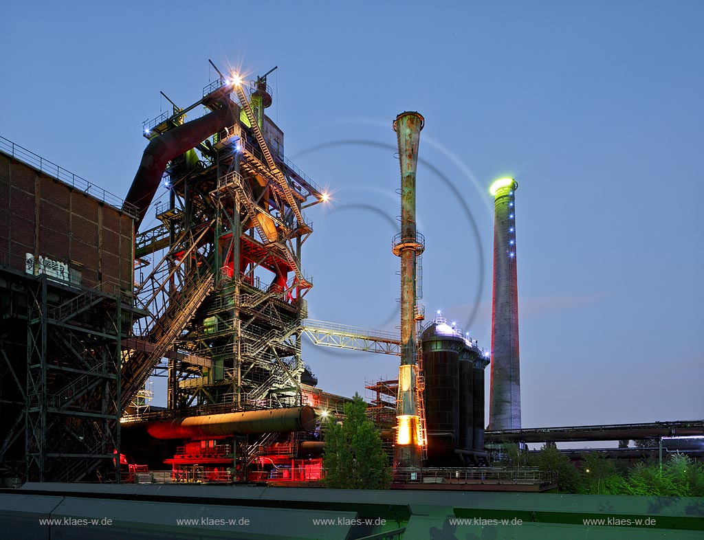 Duisburg Meiderich, der Landschaftspark Duisburg-Nord, auch kurz LaPaDu ist ein etwa 200 Hektar groer Landschaftspark rund um ein stillgelegtes Huettenwerk in Duisburg-Meiderich, das im Rahmen der IBA (Internationale Bauausstellung Emscher Park) entstand. Der Landschaftspark ist einer der Ankerpunkte der Europaeischen Route der Industriekultur sowie der Route der Industriekultur im Ruhrgebiet. Blaue Stunde, Daemmerungsansicht von links nach rechts Windenhaus, Hochofen 2 und Hochofen 5 mit Lichtinstallation, Cowpergruppe am Hochofen 2 und ein Kamin, fotografiert vom Bunkersteg, in Szene gesetzt durch die 1997 installierte Lichtinstallation, Illumination; Duisburg-Meiderich, the Meiderich ironworks are the main feature in the North Duisburg Landscape Park