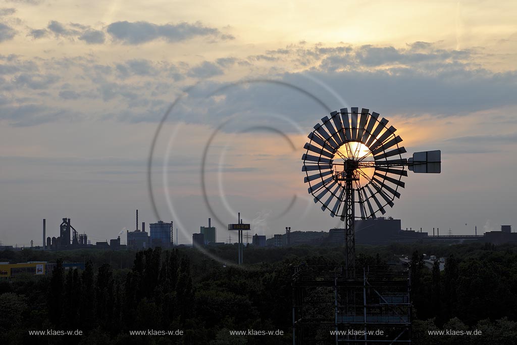 Duisburg Meiderich, der Landschaftspark Duisburg-Nord, auch kurz LaPaDu ist ein etwa 200 Hektar groer Landschaftspark rund um ein stillgelegtes Huettenwerk in Duisburg-Meiderich, das im Rahmen der IBA (Internationale Bauausstellung Emscher Park) entstand. Der Landschaftspark ist einer der Ankerpunkte der Europaeischen Route der Industriekultur sowie der Route der Industriekultur im Ruhrgebiet. Sonnenuntergang, Industrieskyline mit Windenergieturm, im Hintergrund Hochofen 8, betrieben von ThyssenKrupp Steel; Duisburg-Meiderich, the Meiderich ironworks are the main feature in the North Duisburg Landscape Park